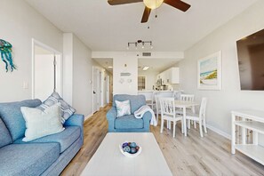 Un salon moderne avec un canapé, une table basse et un coin repas.