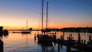 Un puerto tranquilo al atardecer, con barcos amarrados y cielo despejado.