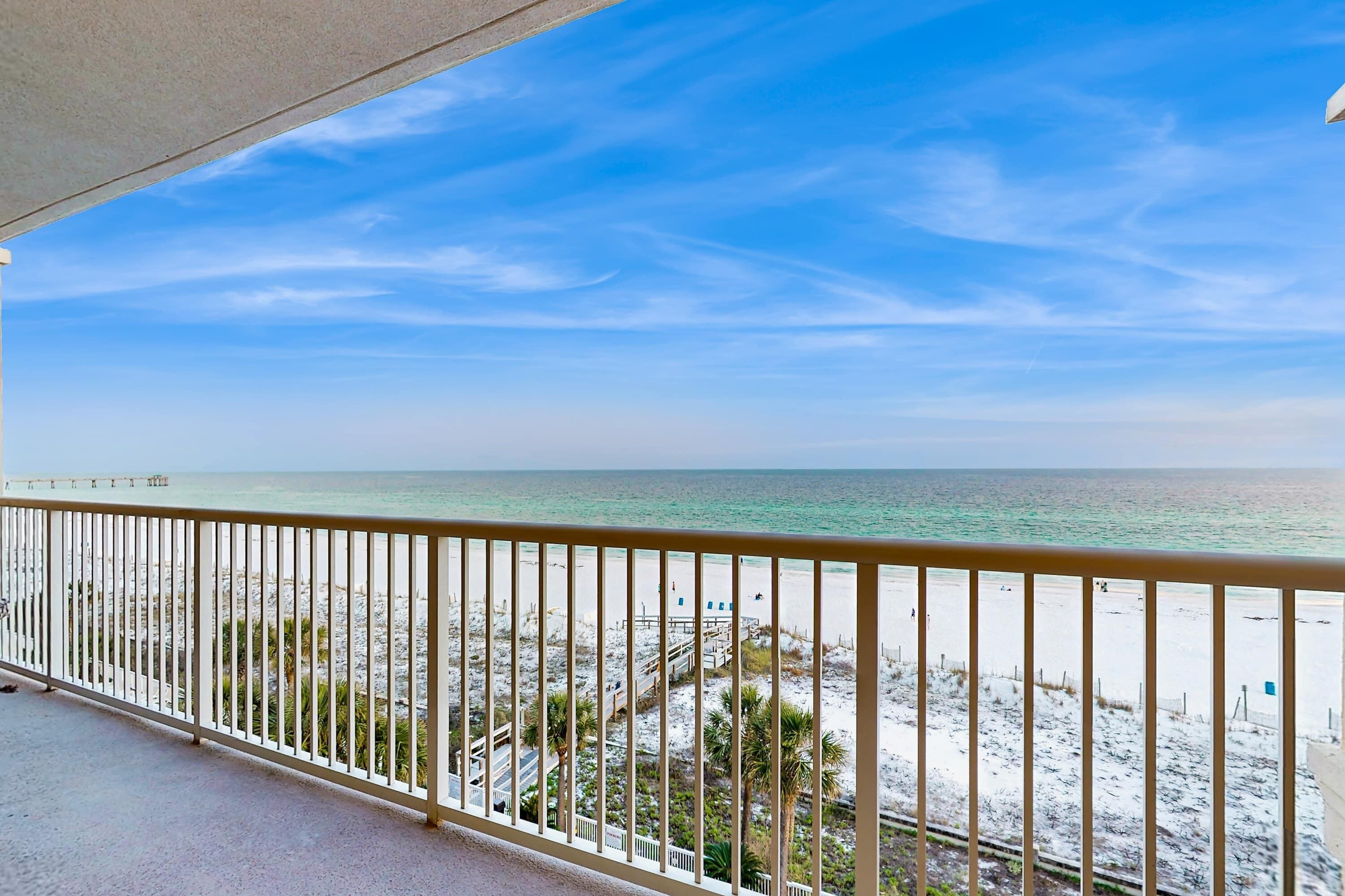 Ein Balkon mit Blick auf Strand und Meer.