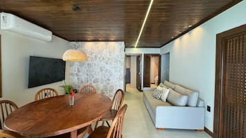 Uma sala de jantar com mesa e cadeiras de madeira, parede decorativa de pedra e design moderno no teto.