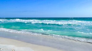 A beach with clear turquoise water and a sandy shore. - Snowbird-friendly Gulf-front condo with outdoor pool & gym (Miramar Beach)