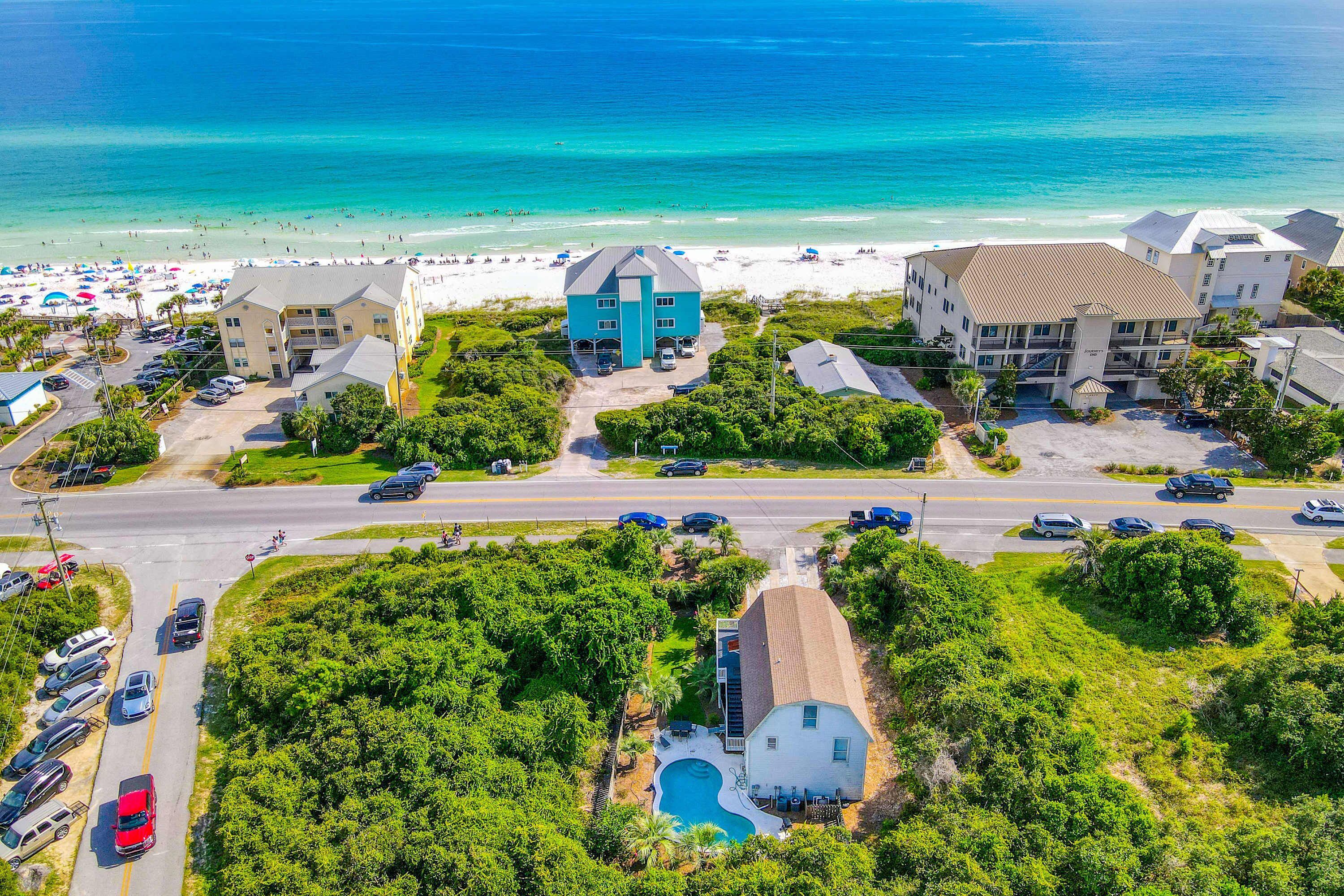 A coastal hotel with a swimming pool, beach access, and multiple parking areas.