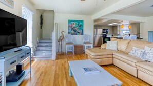 A spacious living room with a large TV, a ceiling fan, and a cozy sectional sofa. - Dog-friendly, Gulf-view home with pool, decks, WiFi, & WD - walk to beach (Santa Rosa Beach)
