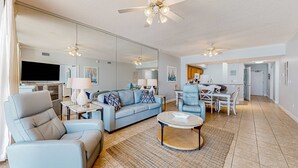Un salón espacioso con un sofá, sillones, una mesa de centro y un comedor.