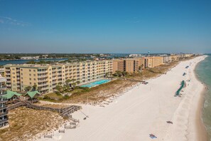 Ein Hotel direkt am Strand mit mehreren Gebäuden, einem Sandstrand und einem Schwimmbad.