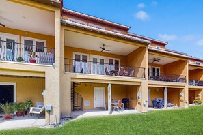 Un hôtel à plusieurs étages doté de balcons, d’un espace extérieur aménagé pour s’asseoir et d’une pelouse bien entretenue.