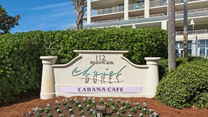 Un panneau indiquant « Ariel Dunes », situé au 112, boulevard Seascape, avec un café-terrasse appelé « Cabana Cafe ».