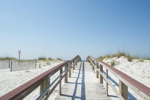 A wooden boardwalk leading to the beach with railings on both sides. - Inviting condo with bay & ocean views, & pool - steps to the beach (Pensacola Beach)