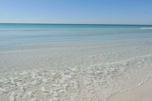 A beach with clear shallow water and a sandy shore. - Fourth floor spacious, beachfront condo with views - close to entertainment (Fort Walton Beach)