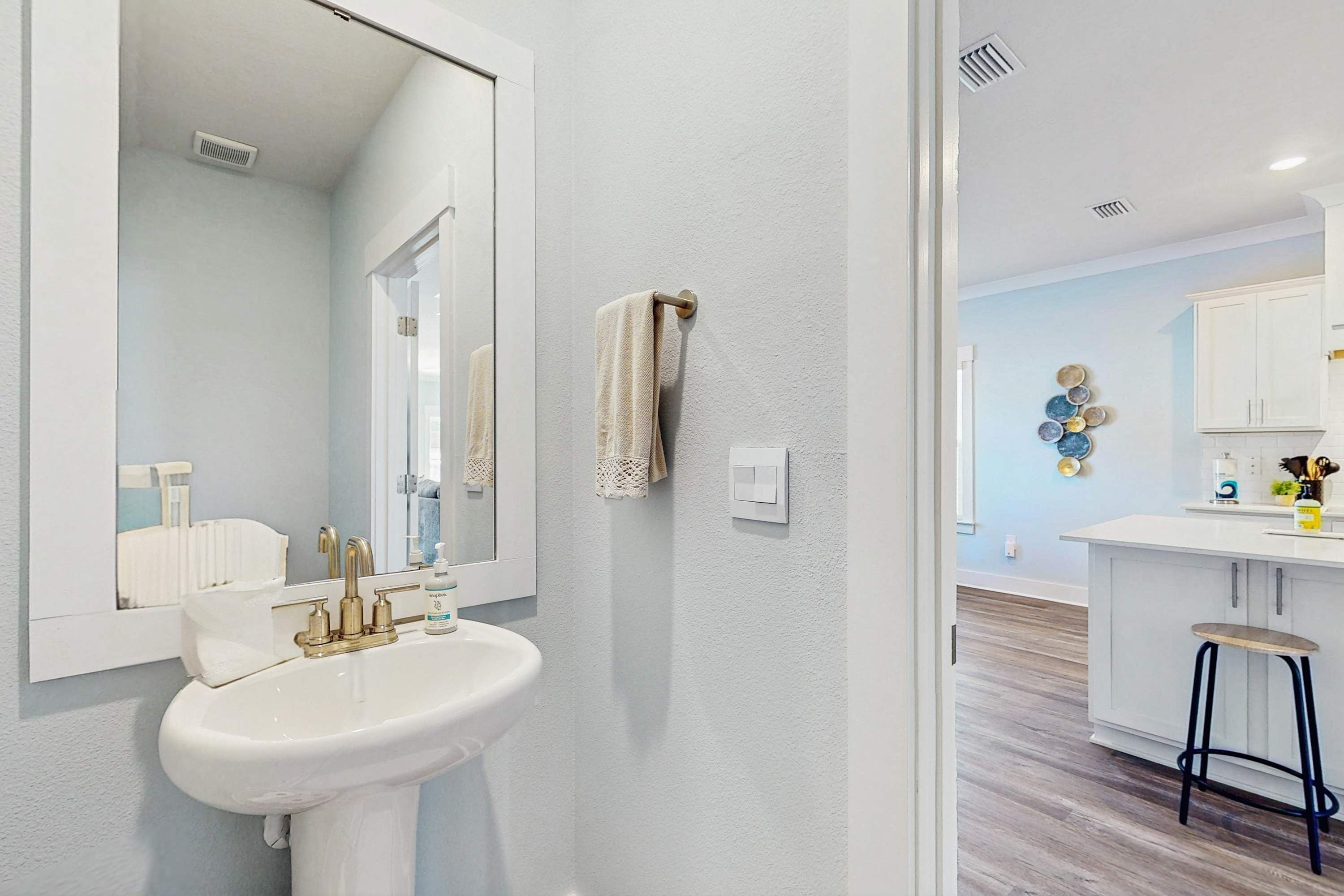 A bathroom with a sink, mirror, and towel rack.