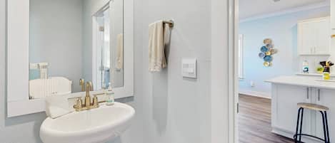 A bathroom with a sink, mirror, and towel rack.