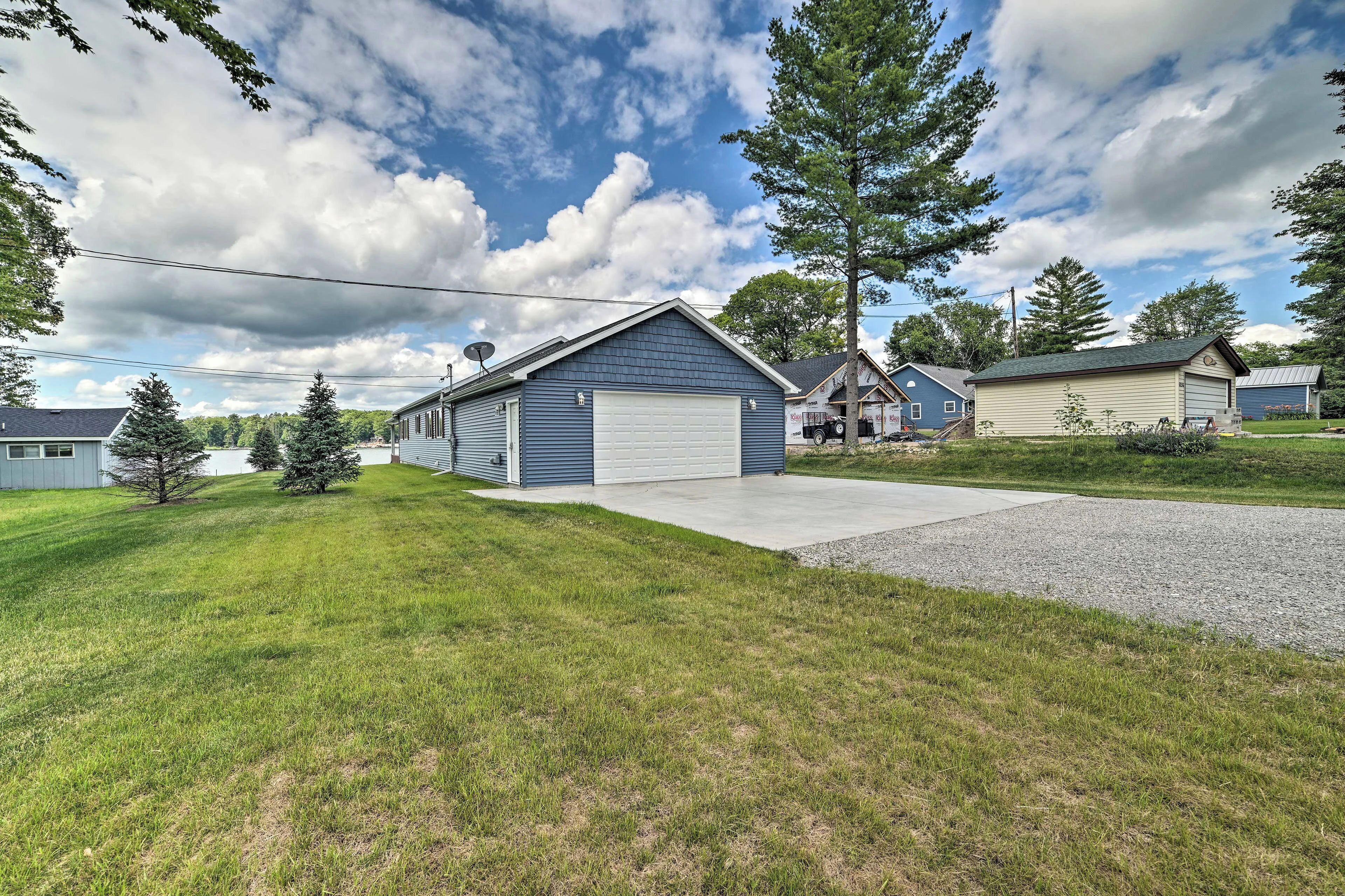 A residential property with a garage, a well-maintained lawn, and a large tree.