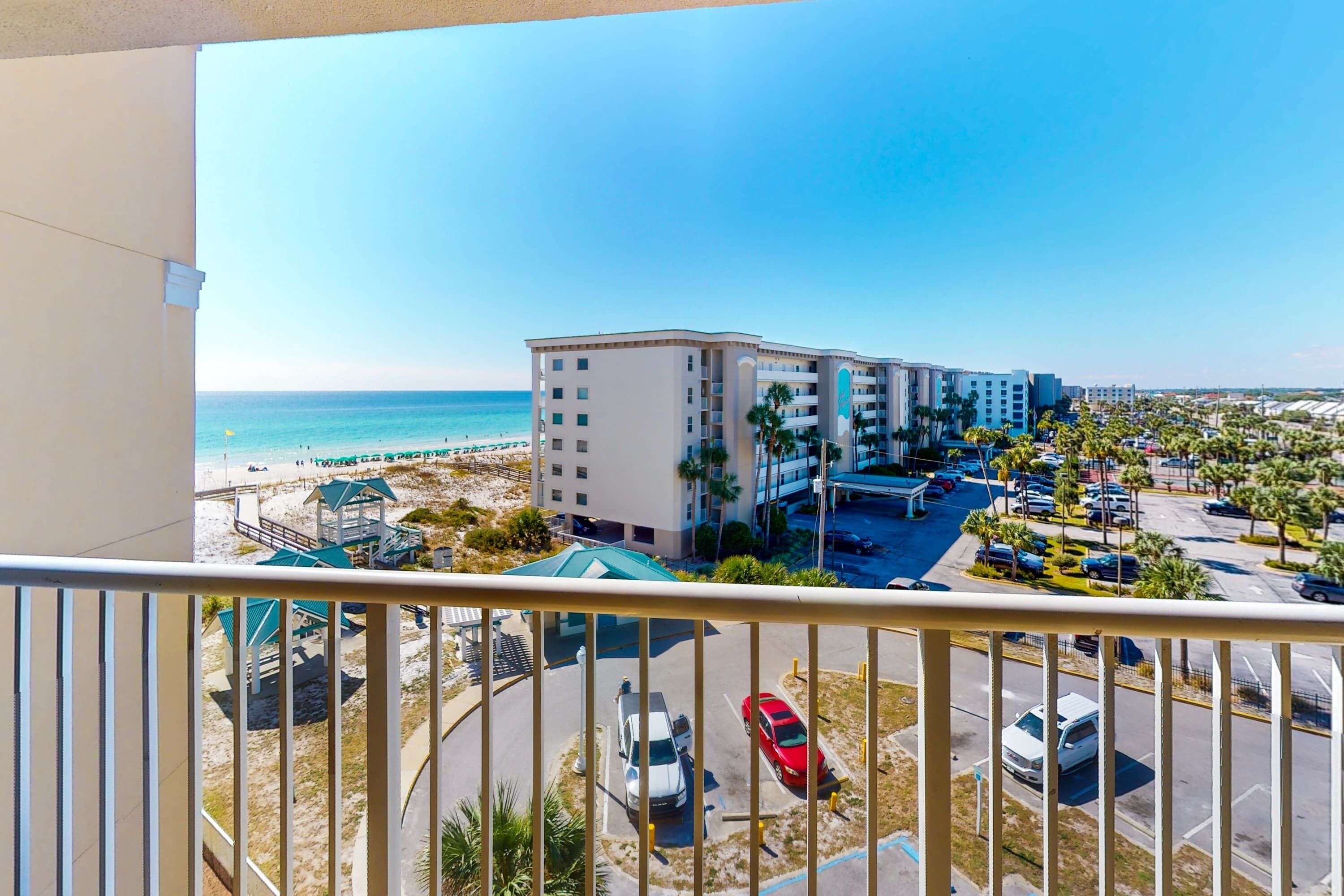 Un hôtel avec vue sur la plage, un parking et plusieurs bâtiments.