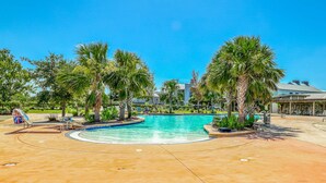 A swimming pool surrounded by palm trees and a children's play area. - Lovely coastal home with pool access, fast WiFi, screened patio & great location (Port St. Joe)