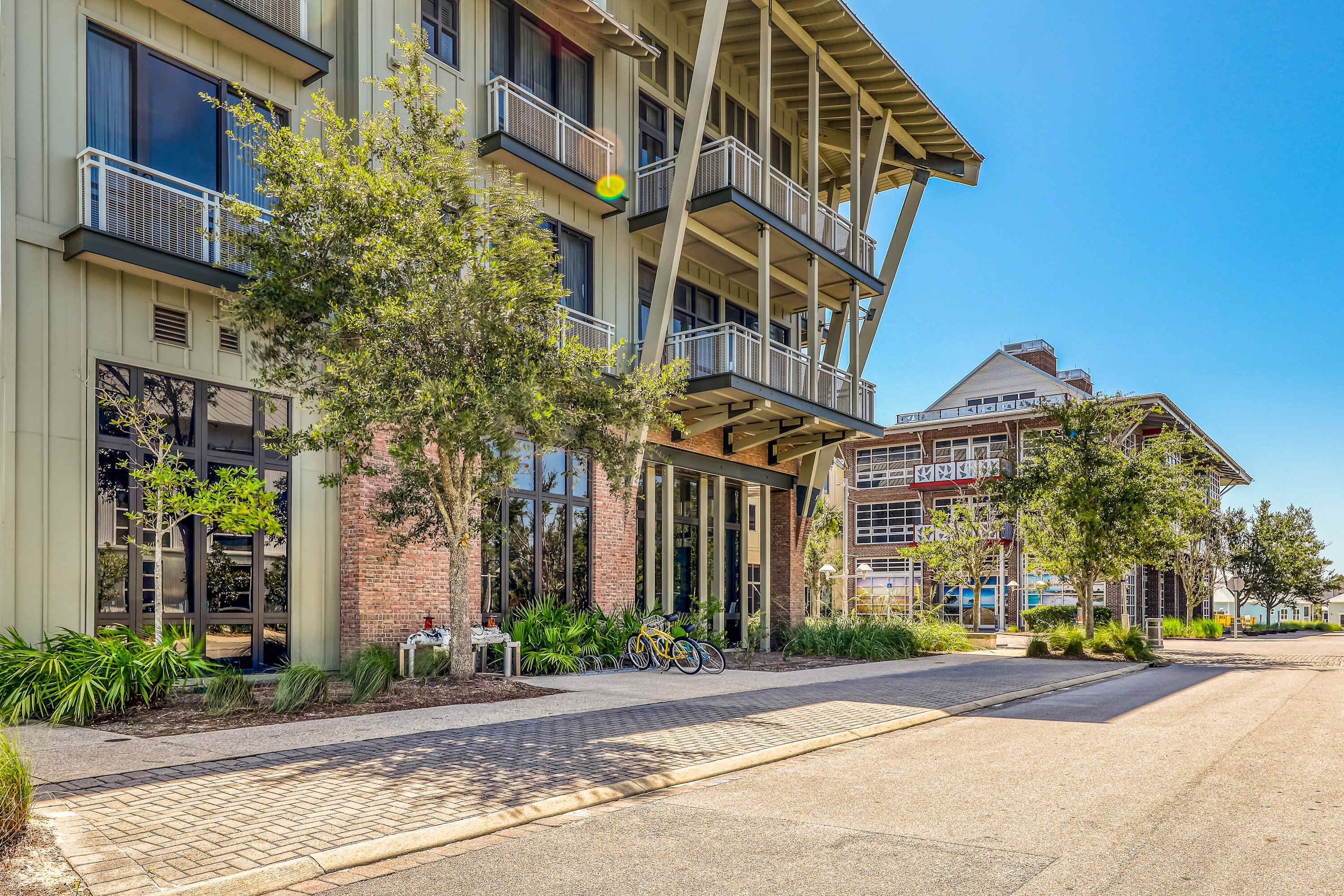 A multi-story building with balconies, large windows, and a brick facade.