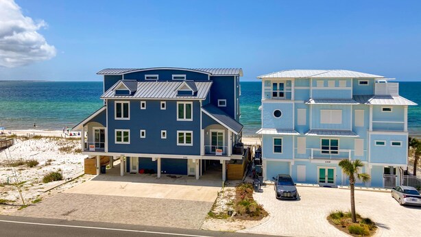 A beachfront hotel with two-story buildings, a covered parking area, and a view of the ocean. - Renovated oceanfront condo with lanai, pool, hot tub & view - snowbird-friendly (Mexico Beach)