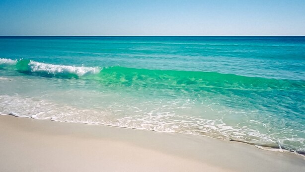 A beach with clear turquoise water and a sandy shore. - Gulf-front condo with balcony, ocean view, W&D, pool, & fitness room (Fort Walton Beach)