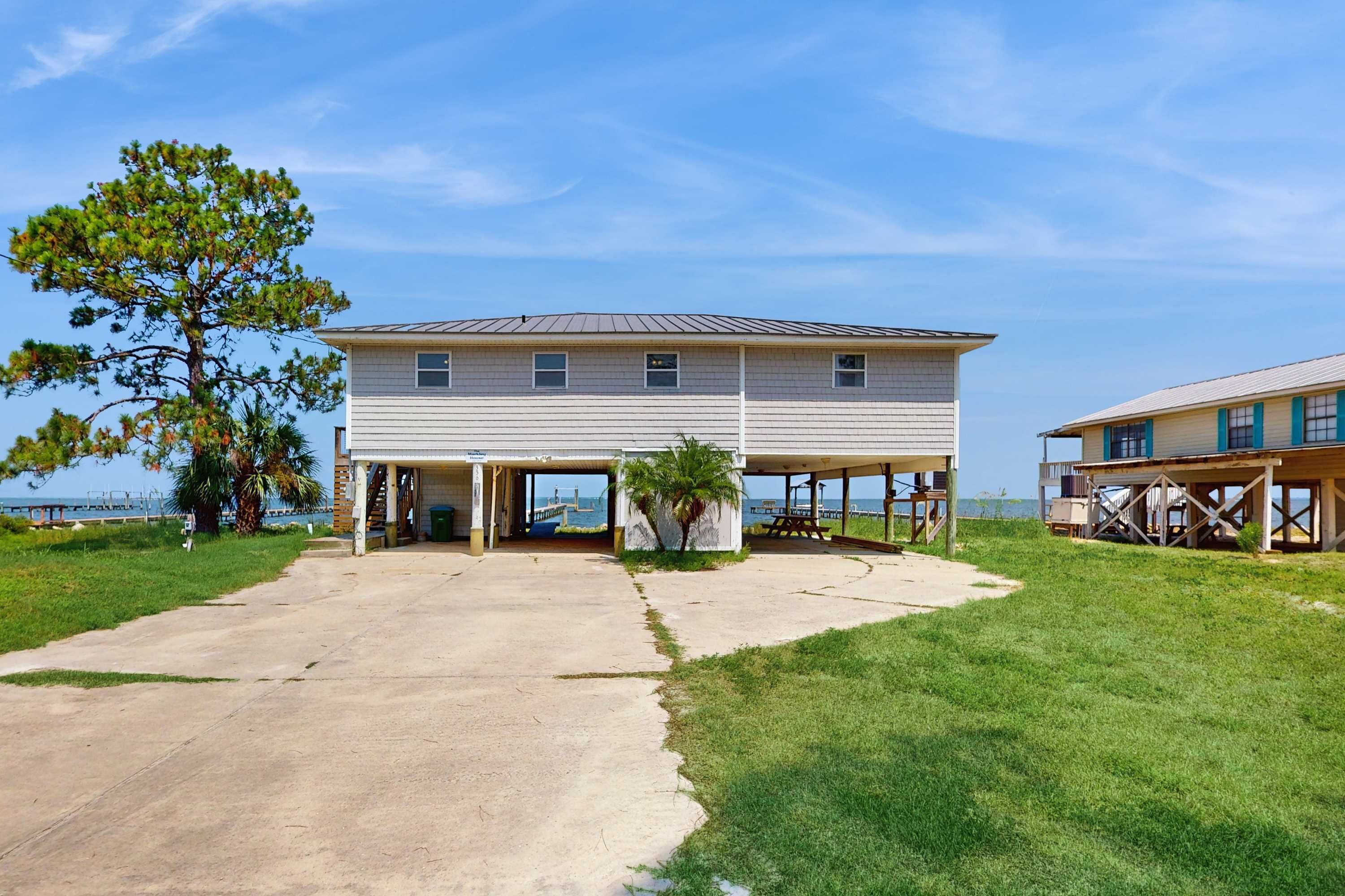 A two-story house with a covered patio area and a view of the ocean.