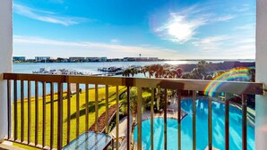 Área da piscina com vista para uma marina e o horizonte da cidade.