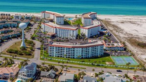 Ein Resort mit mehreren Gebäuden, einem großen Wasserturm und einem Strand.