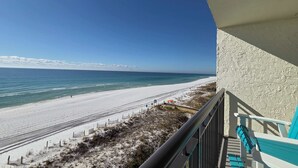 Un balcon avec vue sur une plage et l’océan.