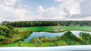 A golf course with a pond, trees, and a clear sky. - Ideal getaway near the beach & golf with shared pool, central AC (Miramar Beach)