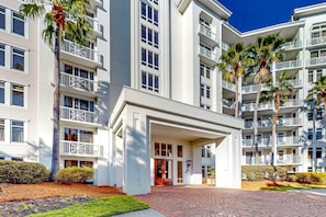 A multi-story hotel with a central entrance, balconies, and palm trees. - Ideal getaway near the beach & golf with shared pool, central AC (Miramar Beach)
