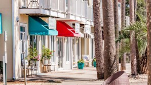 Una hilera de hoteles frente a la playa con terrazas al aire libre y palmeras.