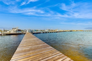 A wooden pier extending into calm water with boats docked at the end. - Peaceful corner studio with pool & Santa Rosa Sound views - snowbird-friendly (Fort Walton Beach)