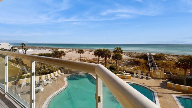 Ein Poolbereich mit Blick auf Strand und Meer.