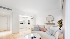 Ein modernes Wohnzimmer mit einer Couch, einem Couchtisch und einer Fernbedienung darauf.