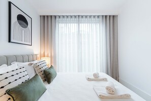 A hotel room with a bed, pillows, a framed picture, and sheer curtains. - Bolhão Luxe | High-End Retreat by the Market (Porto)