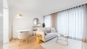Ein modernes Wohnzimmer mit einem weißen Sofa, einem runden Couchtisch und einer Stehlampe.
