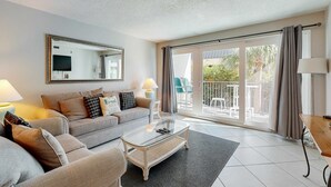 Ein modernes Wohnzimmer mit einer Couch, einem Couchtisch und einem großen Spiegel.