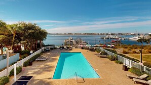 A swimming pool with a view of the marina and boats. - Second-story waterfront condo with pool view, W/D, AC - perfect location (Pensacola Beach)