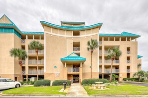A multi-story hotel with a curved facade, balconies, and palm trees. - 3rd Floor Condo with Shared Pools,Tennis, Private W&D, WiFi, and Central AC (Miramar Beach)