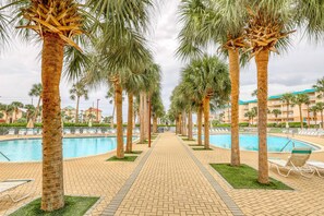 A poolside area with palm trees, lounge chairs, and a clear sky. - 3rd Floor Condo with Shared Pools,Tennis, Private W&D, WiFi, and Central AC (Miramar Beach)