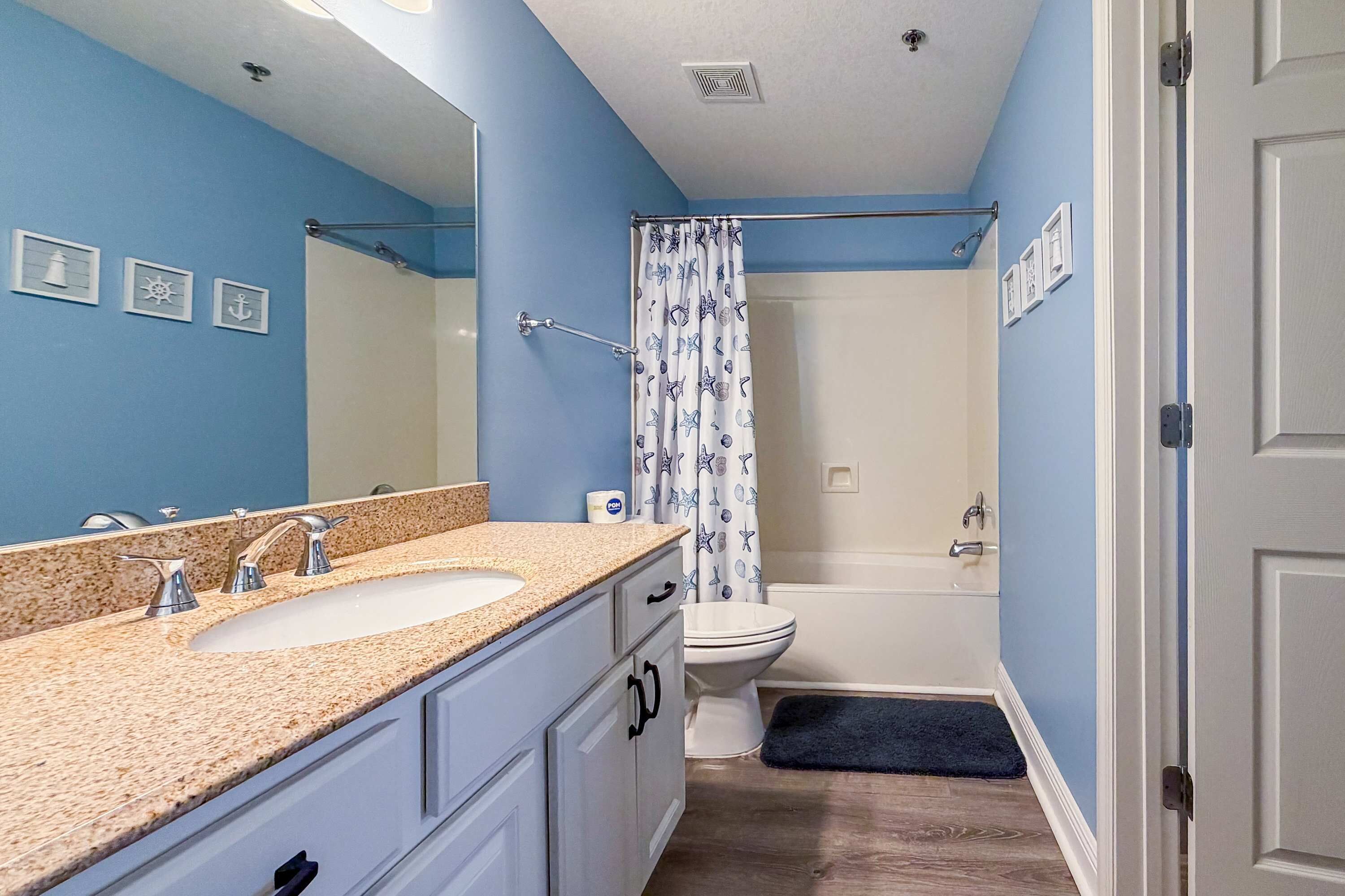 A bathroom with two sinks, a shower, and a toilet.