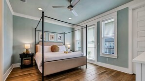 A four-poster bed in a room with wooden flooring, a ceiling fan, and two bedside lamps. - Koko Kabana in Hidden Palms (Miramar Beach)