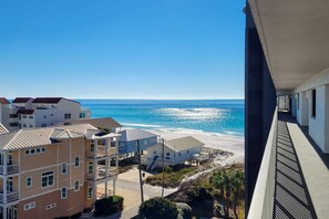 A beachfront hotel with multiple buildings, a clear view of the ocean, and a balcony overlooking the beach. - Gulf-front condo with pool, hot tub & included beach service (Miramar Beach)