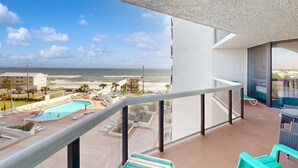 Un balcón con vistas a una piscina y una playa.