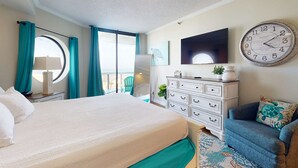 Un dormitorio con cama, cómoda, televisor y reloj en la pared.