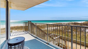 Een balkon met uitzicht op strand en zee.