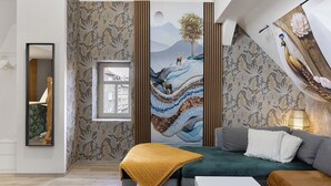 A modern living room with a sofa, a coffee table, and a large painting on the wall. - Apartment Vierjahreszeiten Herbst – Spacious Family Retreat in Bad Langensalza (Bad Langensalza)