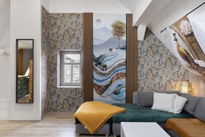 Ein modernes Wohnzimmer mit einer Couch, einem Couchtisch und einem großen Gemälde an der Wand.
