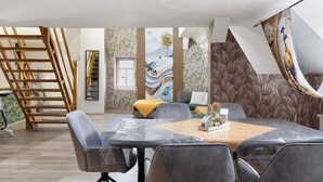 A modern interior with a dining area, a staircase, and a mural on the wall. - Apartment Vierjahreszeiten Herbst – Spacious Family Retreat in Bad Langensalza (Bad Langensalza)