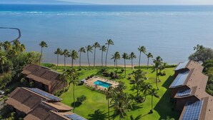 Un resort con piscina, paneles solares y vistas al océano.