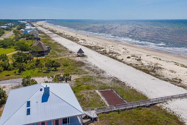 Ein Küsteneigentum mit Strandblick, ein kleines Pavillon und eine Treppe, die zu einem Haus führt.