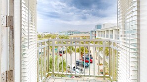 A balcony with a view of parked cars and buildings in the background. - Cozy Hotel-Style- near beach & dining with kitchenette, pools, hot tub, & tennis (Santa Rosa Beach)