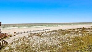 Ein Strand mit einer Holzkonstruktion, einem Zaun und einem Schild.